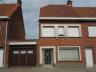 Rijwoning bestaande uit: inkom, ruime living, keuken en bijkeuken, kelder, wasplaats, douche, garage